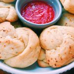 Garlic knots on a plate with marinara sauce