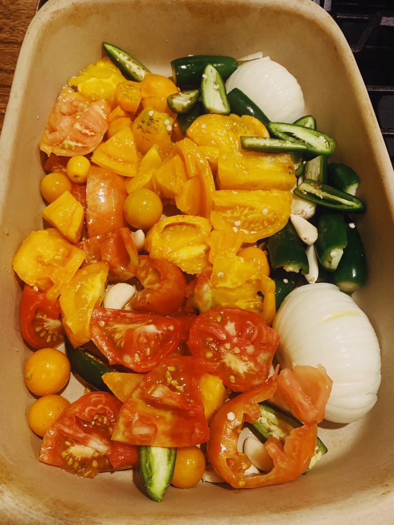 Tomatoes, jalapeno peppers. onions, and garlic in a pan to be roasted for salsa. 