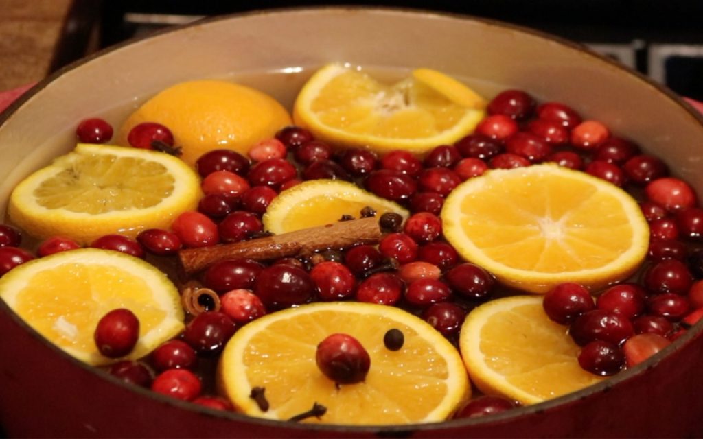 stock pot with water, orange slices, cloves, cranberries and allspice berries