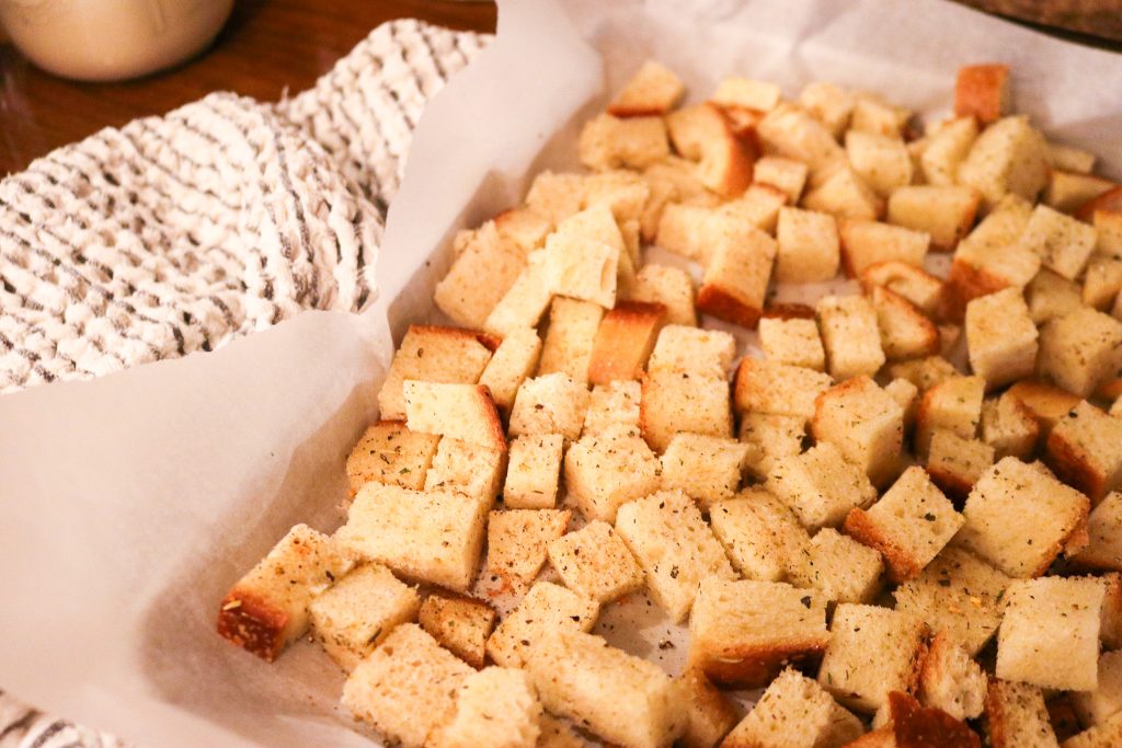 unbaked seasoned croutons on parchment paper