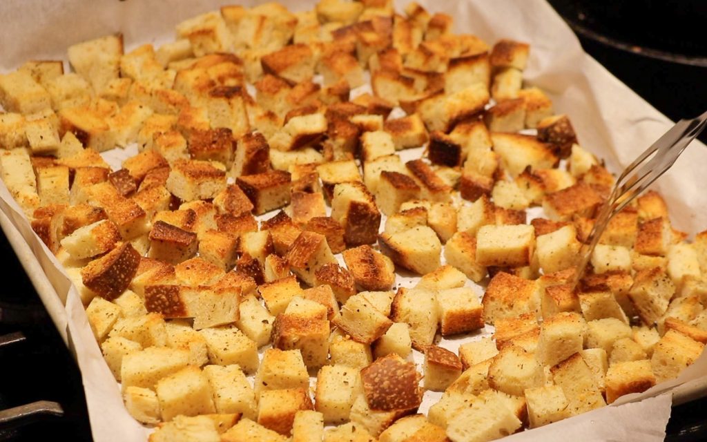 spatula flipping baked sourdough croutons