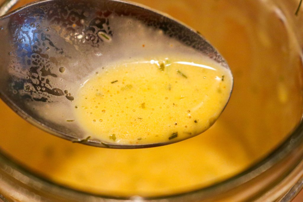 butter sauce on a spoon over a jar