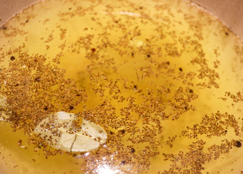 water with salt, bay leaves, garlic cloves, celery seeds, and black peppercorns