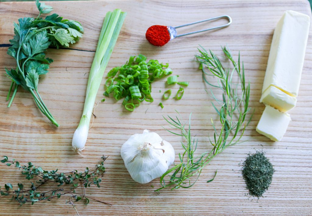 a wooden cutting board with herbs and spices