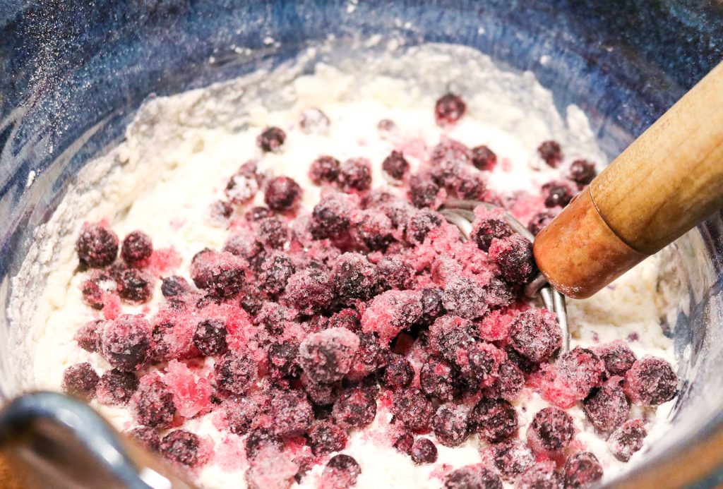 bowl with blueberries on top of biscuit batter